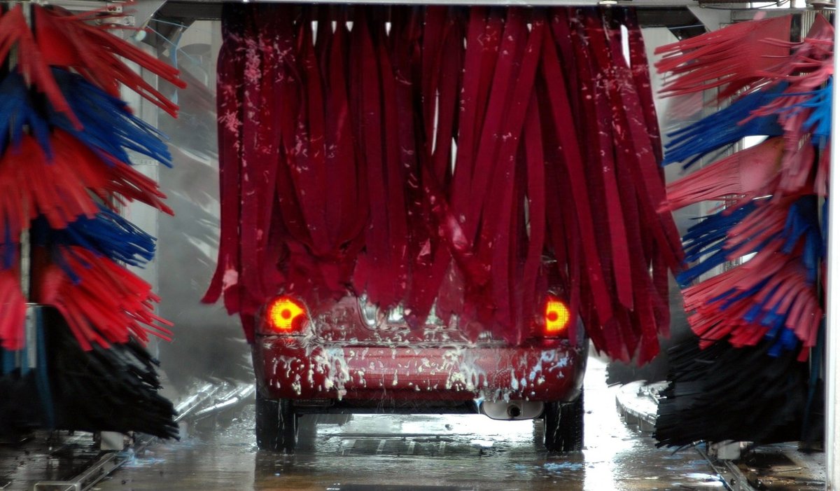 Soft cloth working across the back of a car during the wash